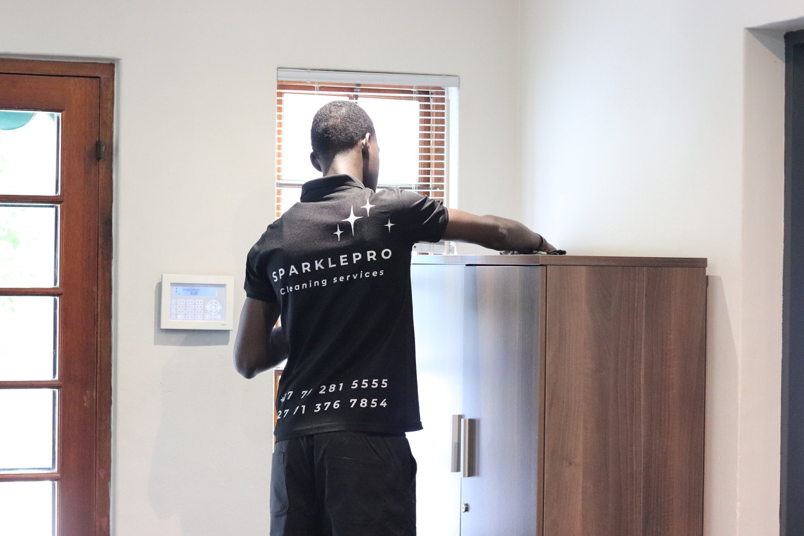 A SparklePro team member cleaning office furniture